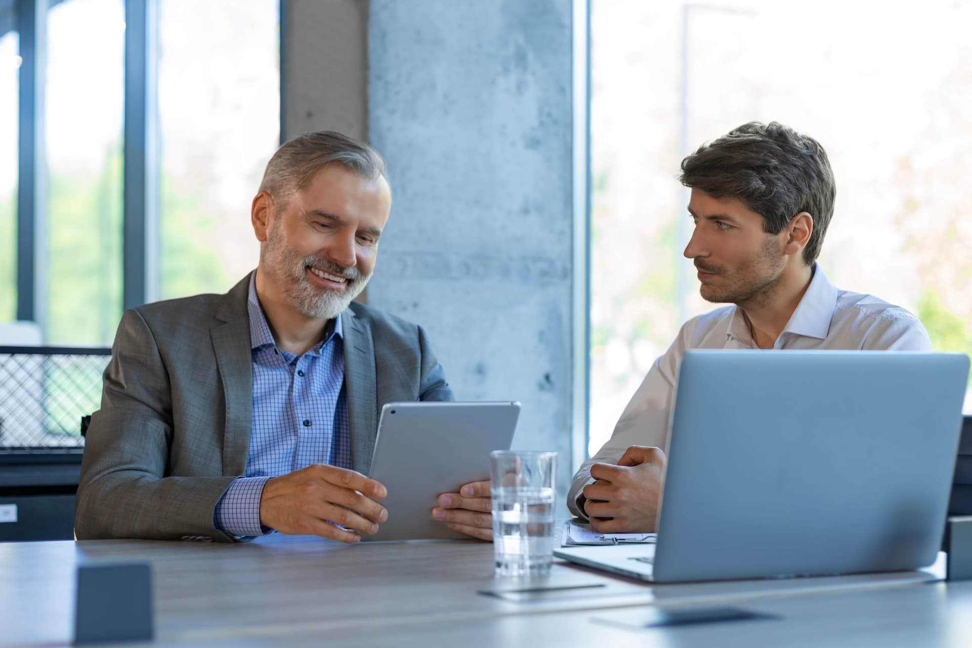 two business people discussing work using tablet